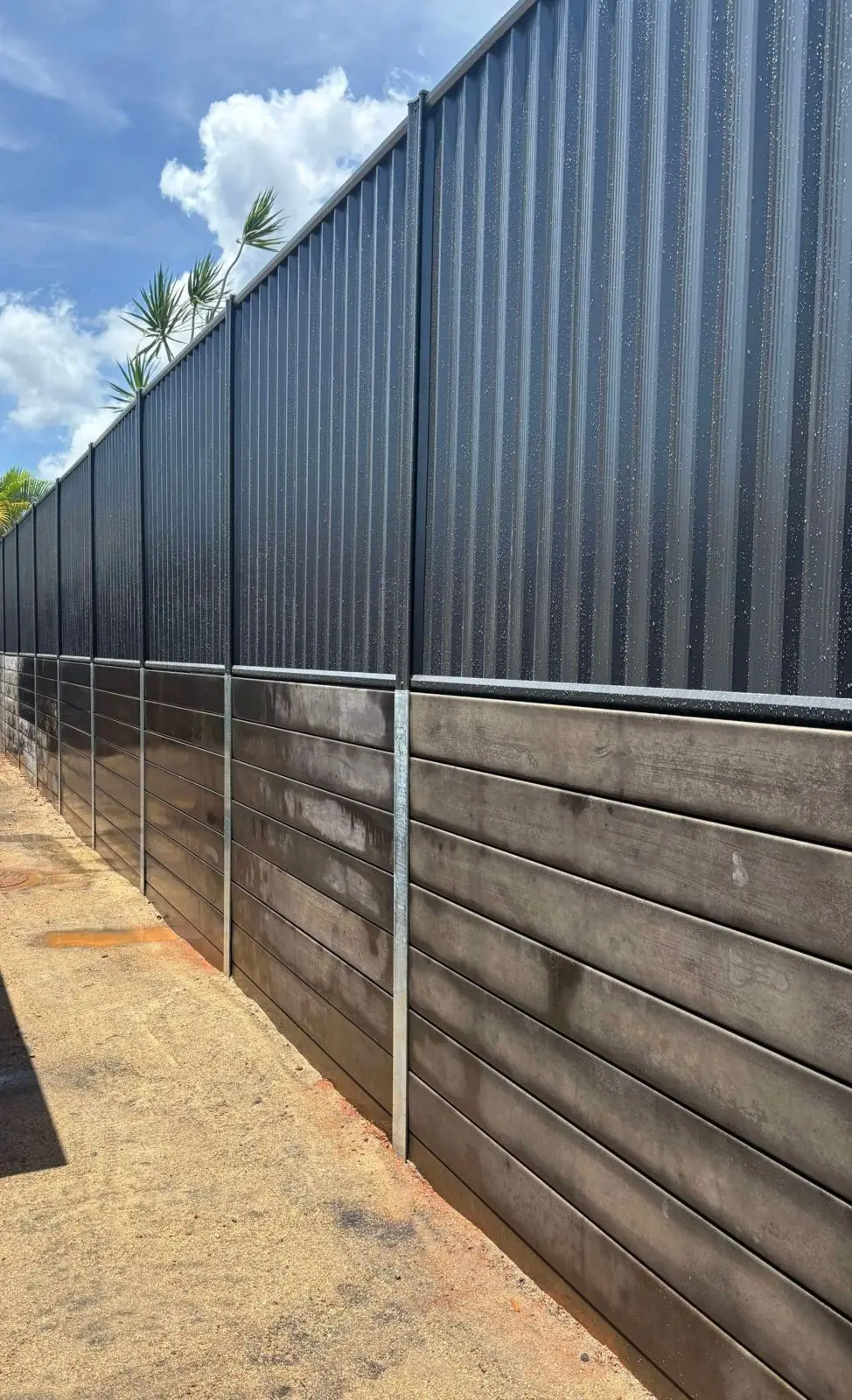 Black Colorbond fence on black concrete sleeper wall