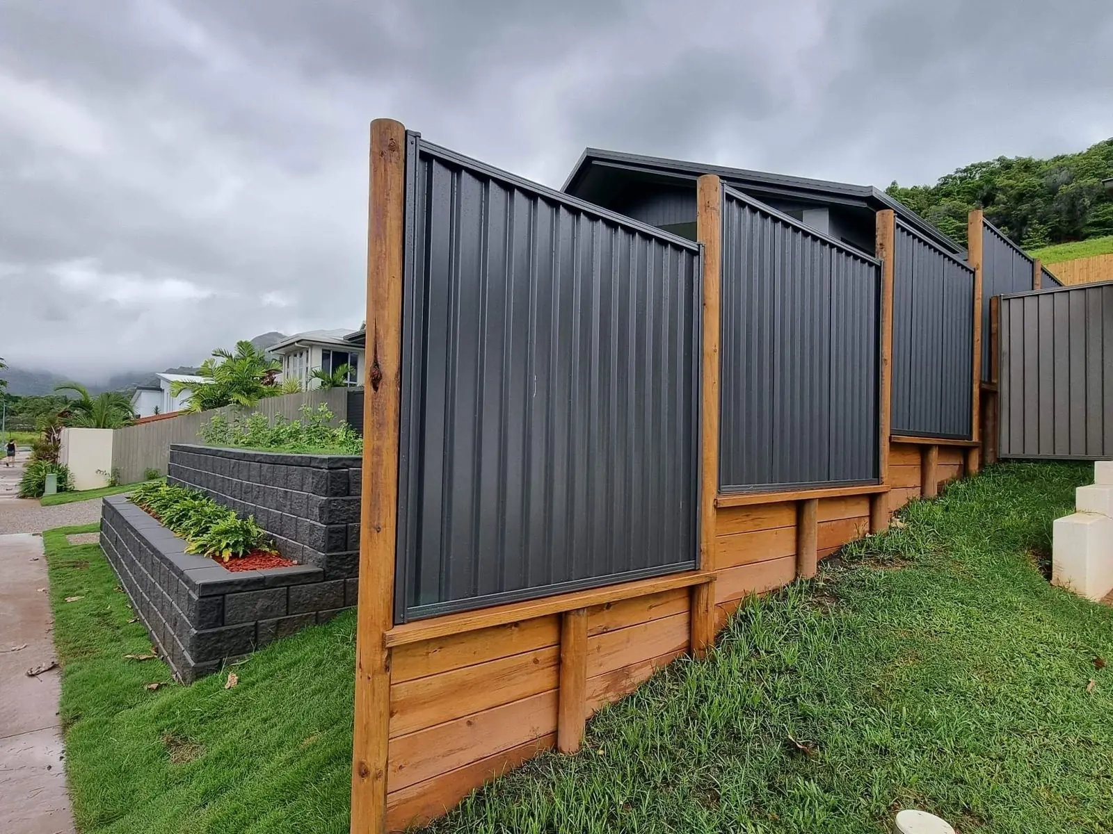 Stepped Colorbond panels on a timber sleeper retaining wall
