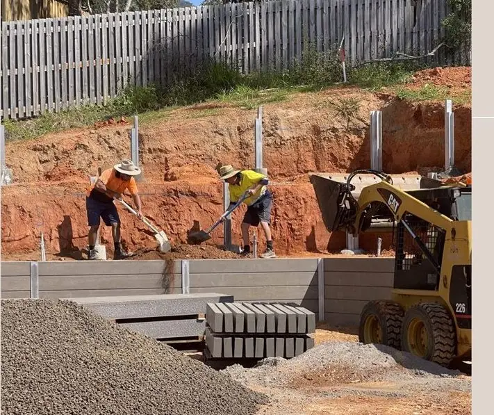 QuickDig crew building a concrete sleeper retaining wall