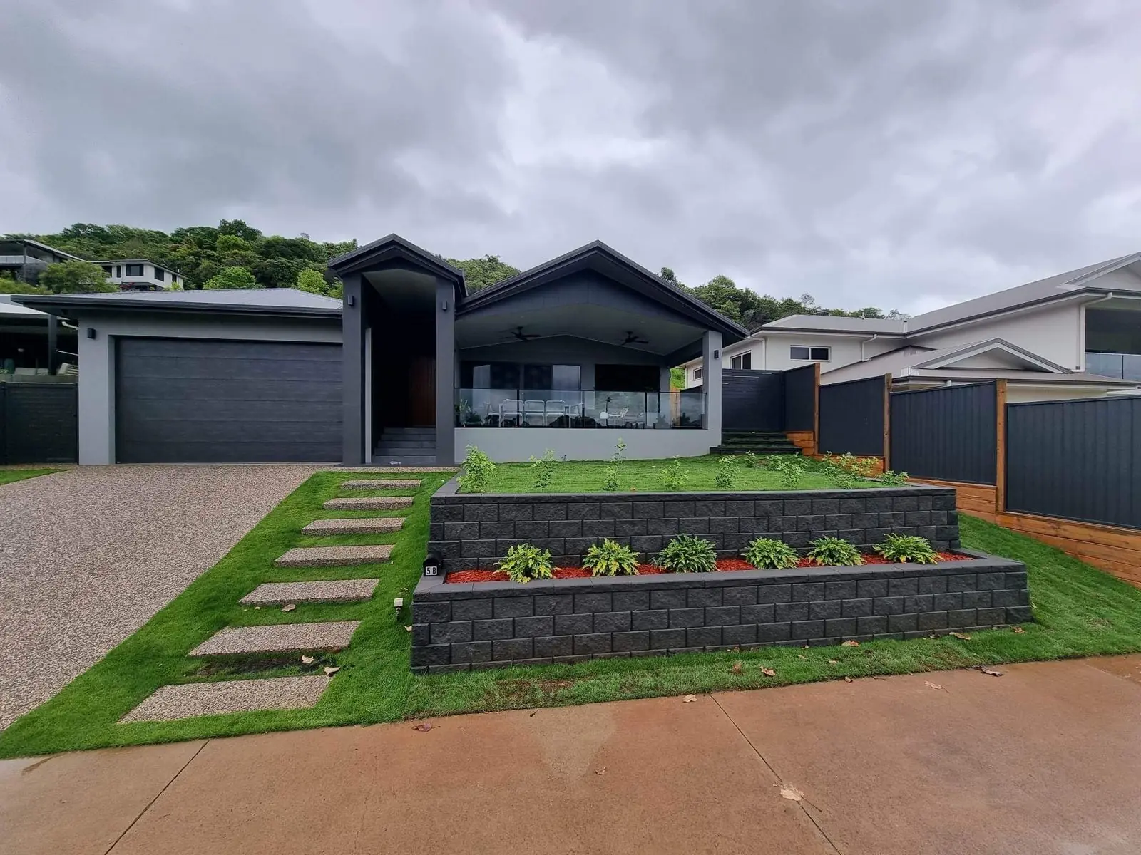 Finished front yard with two-tier block walls, turf and stepping pads