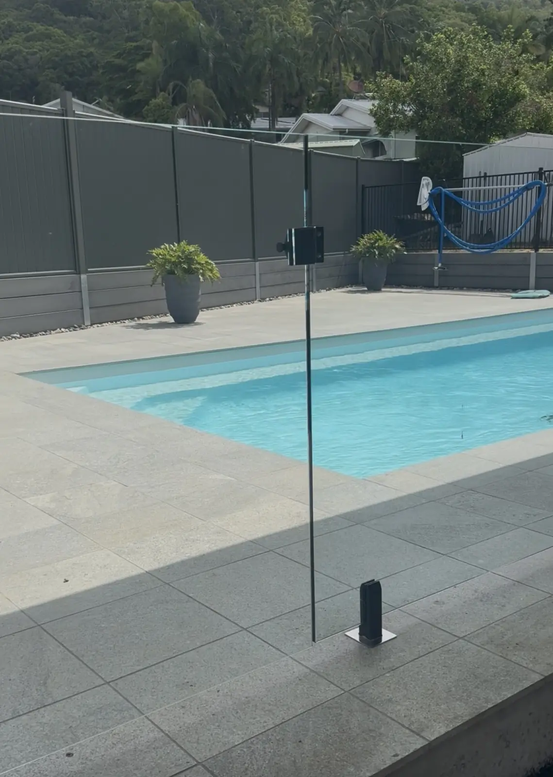 Frameless glass pool fence with black spigots