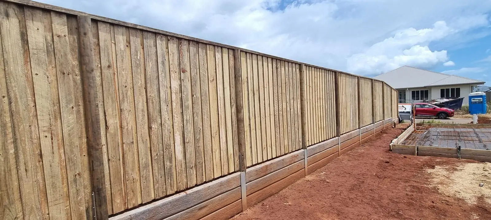 Lapped timber fence over woodgrain concrete sleeper wall
