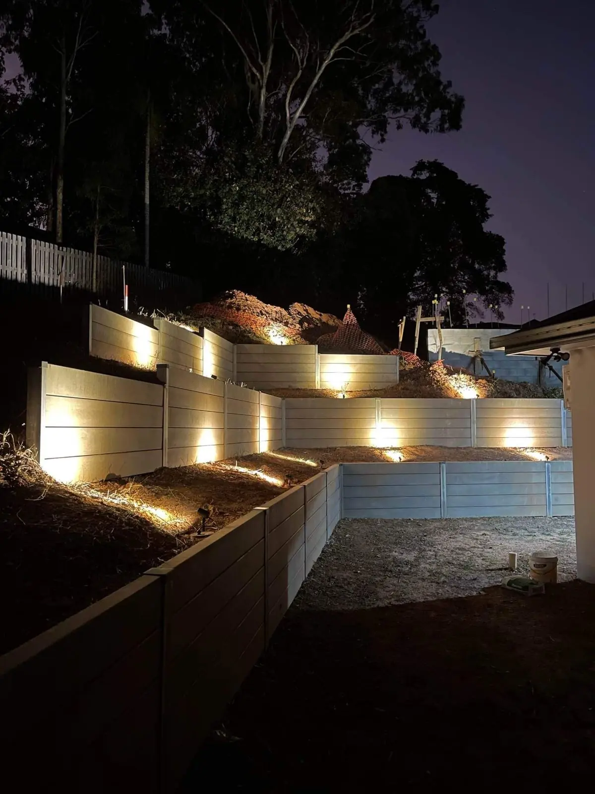 Tiered concrete sleeper walls lit at night