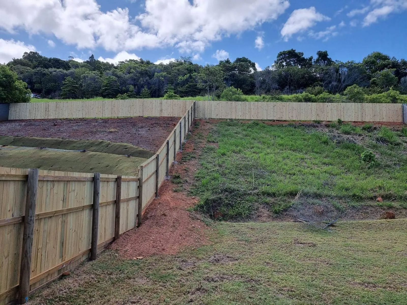Long treated pine paling fence stepping up a slope