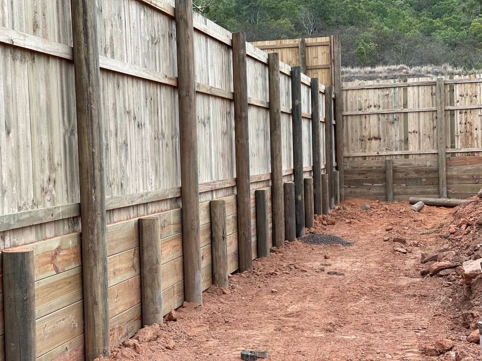 Paling fence over pine retaining wall