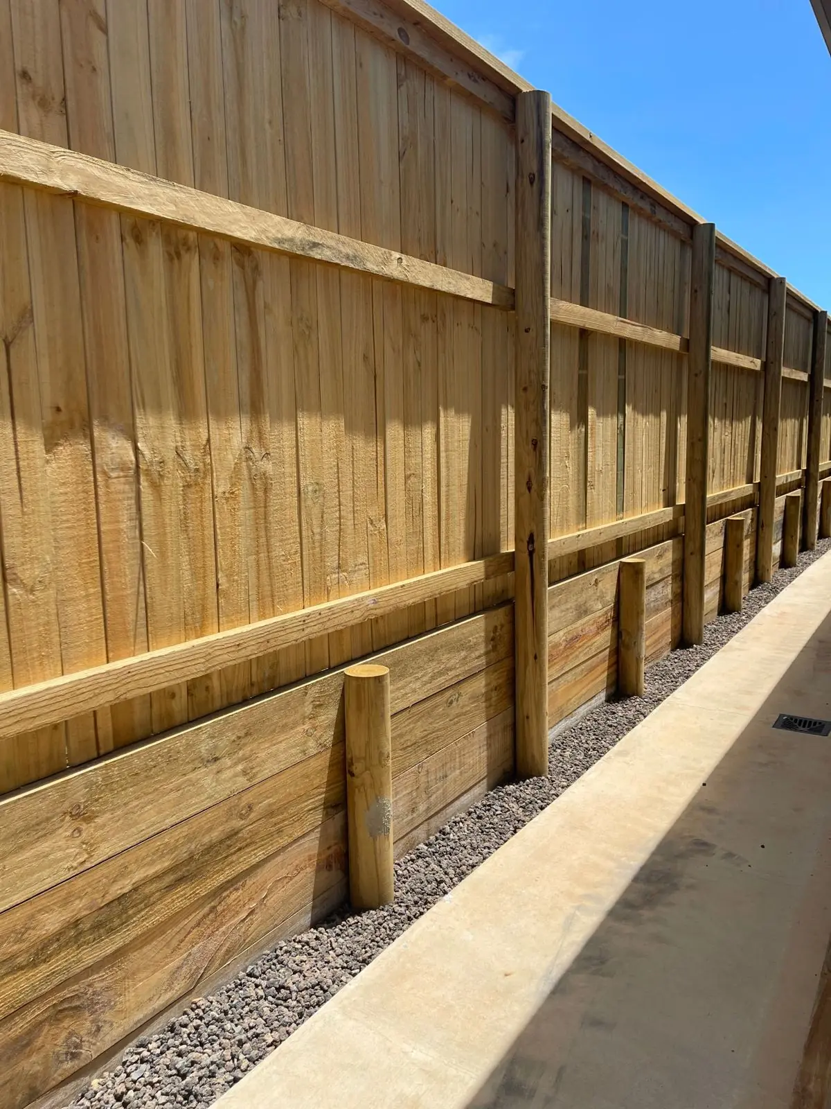 Paling fence over a treated pine sleeper wall