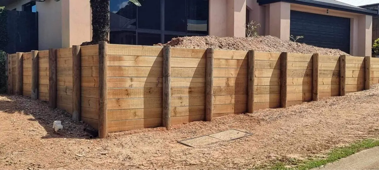 Treated pine sleeper retaining wall with round posts