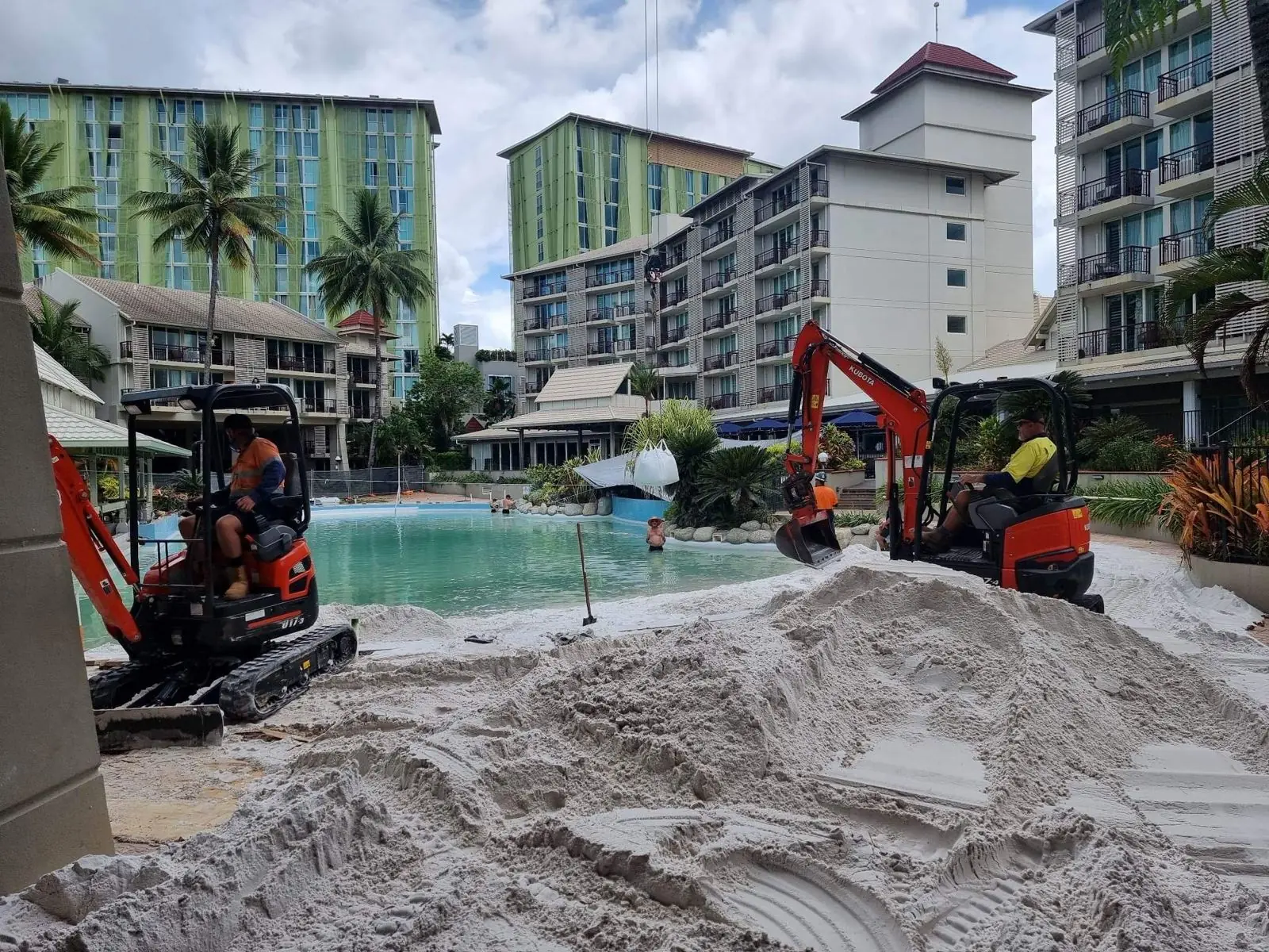 Two mini excavators working on a Cairns resort lagoon pool
