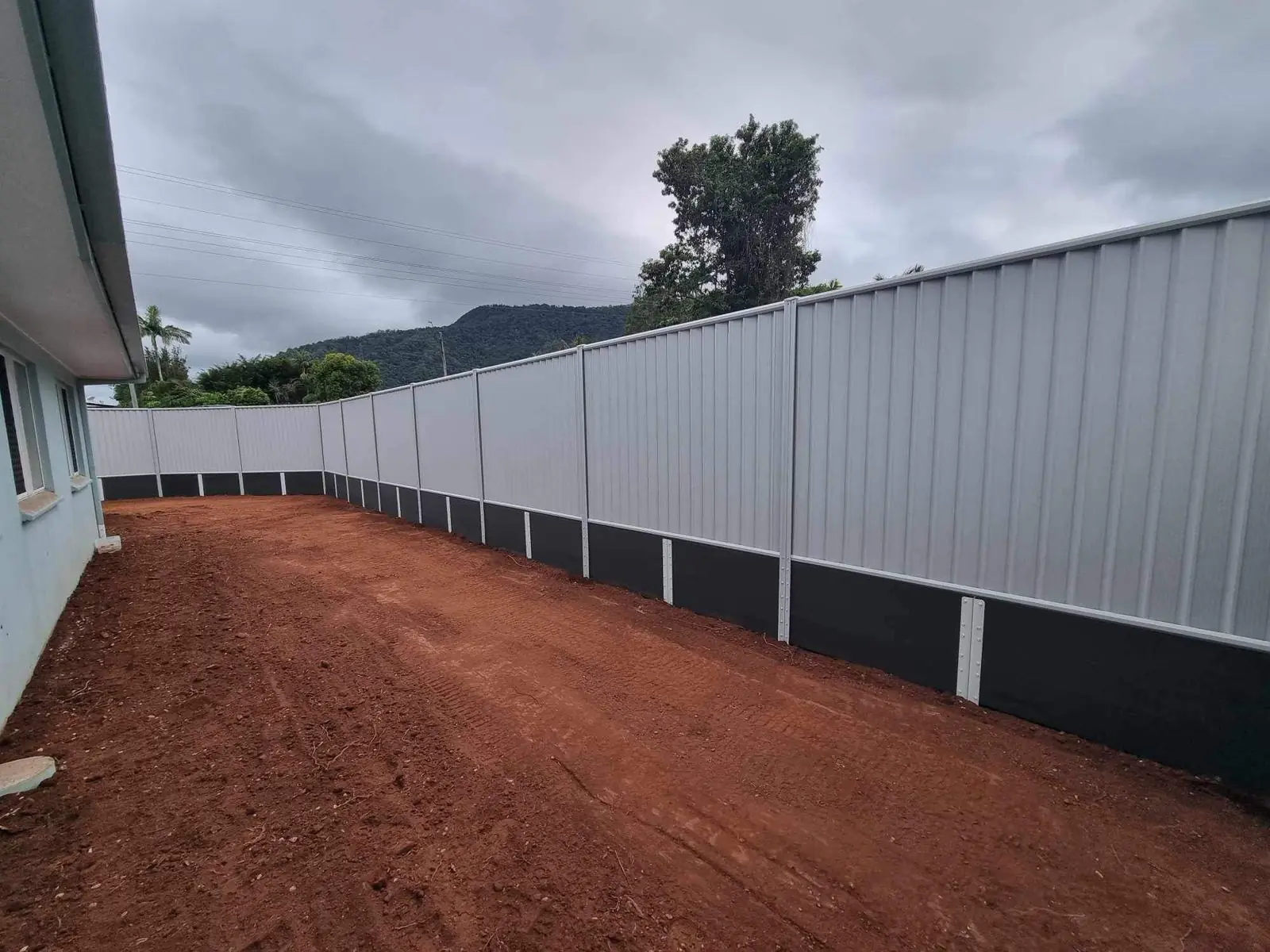 Colorbond fence over charcoal composite sleepers